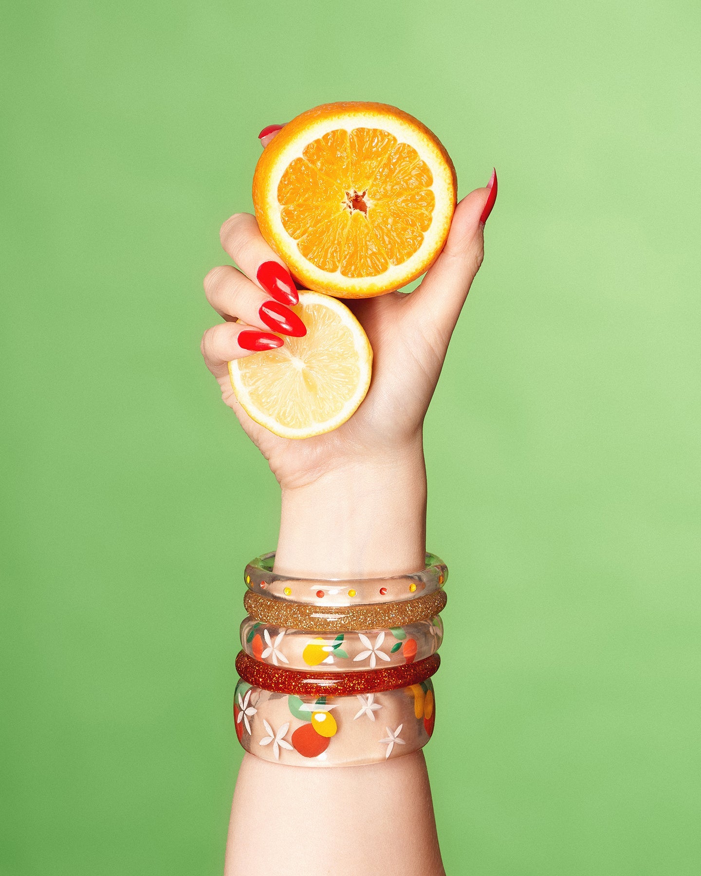 Splendette vintage inspired 1940s style orange and yellow fakelite Citrus jewellery with hand model holding oranges and lemons