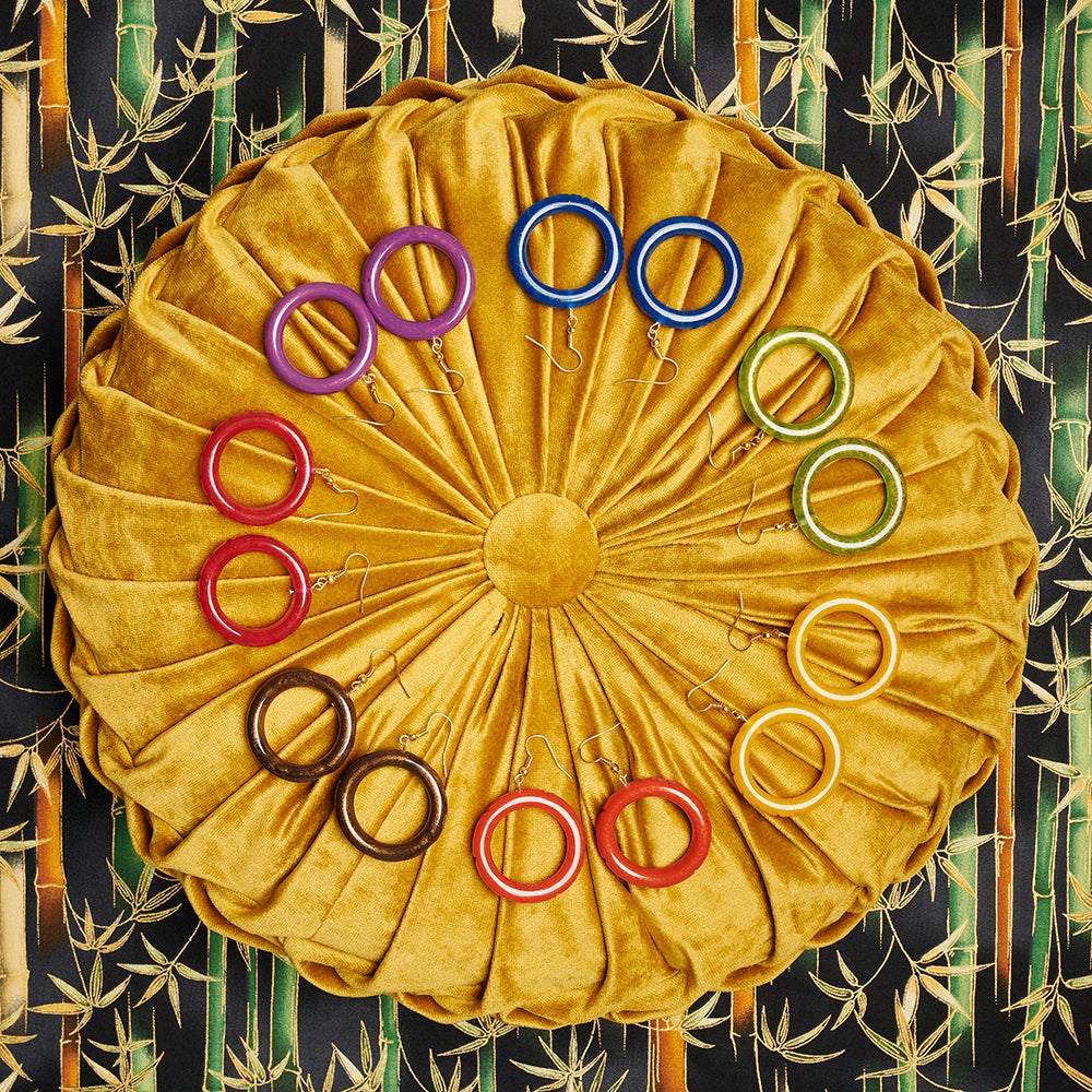 Splendette vintage inspired 1940s style flat lay of Autumn 2020 Golden fakelite Drop Hoop Earrings on golden cushion
