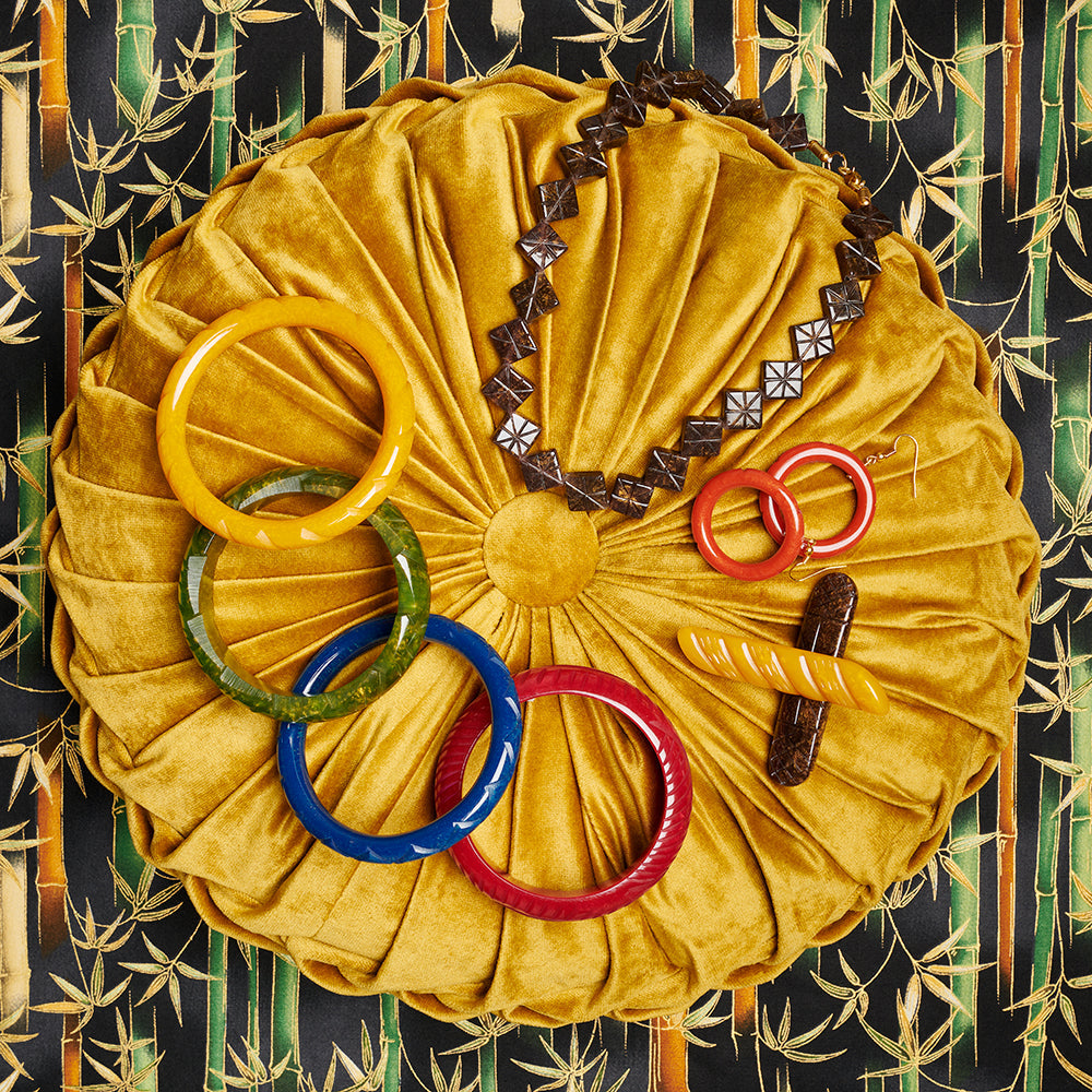 Splendette vintage inspired 1940s style flat lay of Autumn 2020 Golden fakelite jewellery and hair accessories on golden cushion