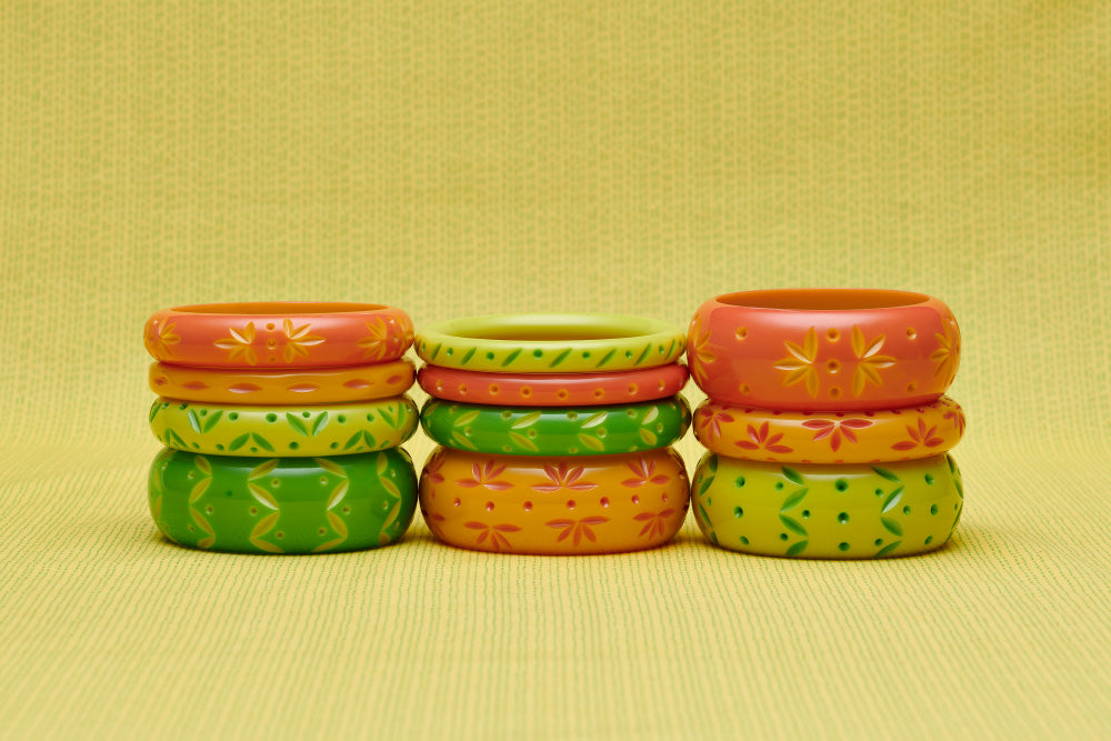 Splendette vintage inspired 1950s style peachy orange, yellow and bright green carved Spring 2021 Duotone fakelite bangles in three stacks. Honeysuckle, Freesia, Lime and Zest