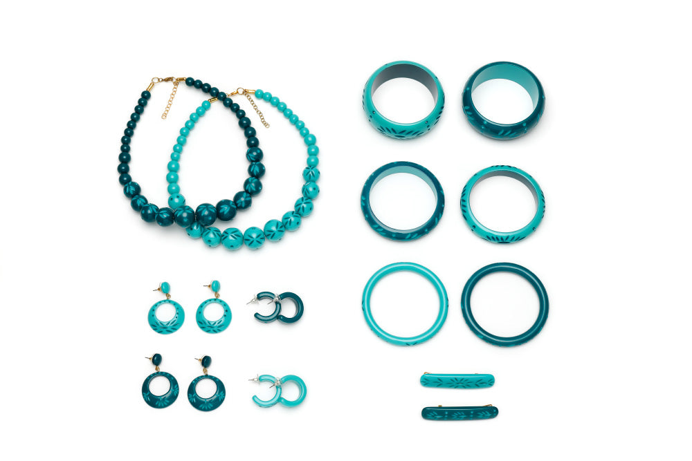 Splendette vintage inspired 1950s tropical style teal and turquoise carved Duotone fakelite jewellery flat lay with bangles, bead necklaces, earrings and hair barrettes